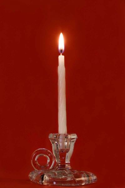 Burning candle in a glass candle holder